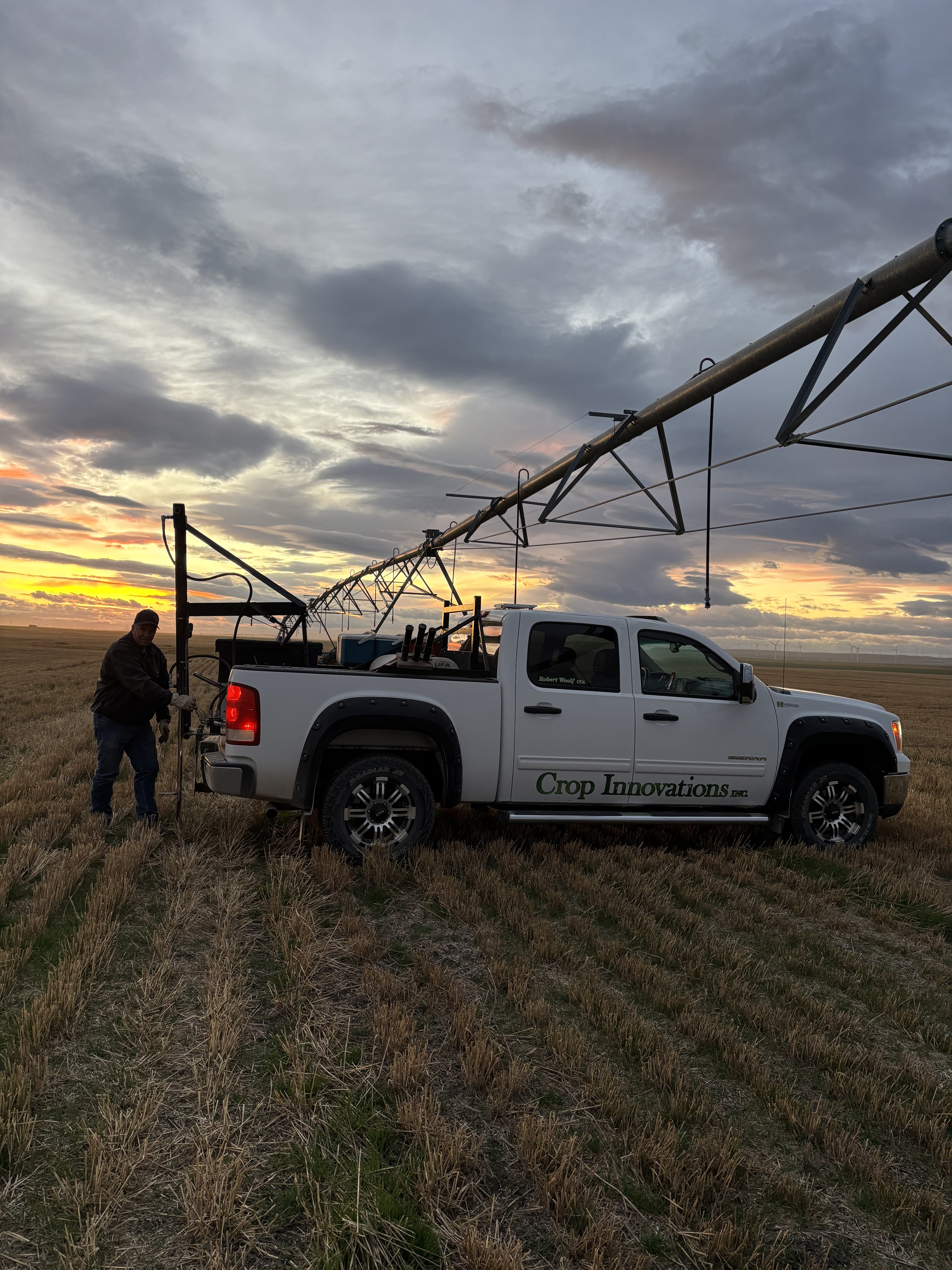 Robert soil sampling beside the Crop Innovations truck beneath an irrigation pivot